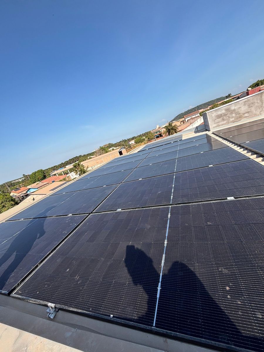 Usina solar sobre laje, com a cidade ao fundo